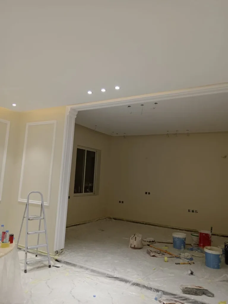 مشهد لأعمال تشطيب دهانات داخلية في منزل بالرياض، يظهر دهان الجدران بدرجة بيج دافئة