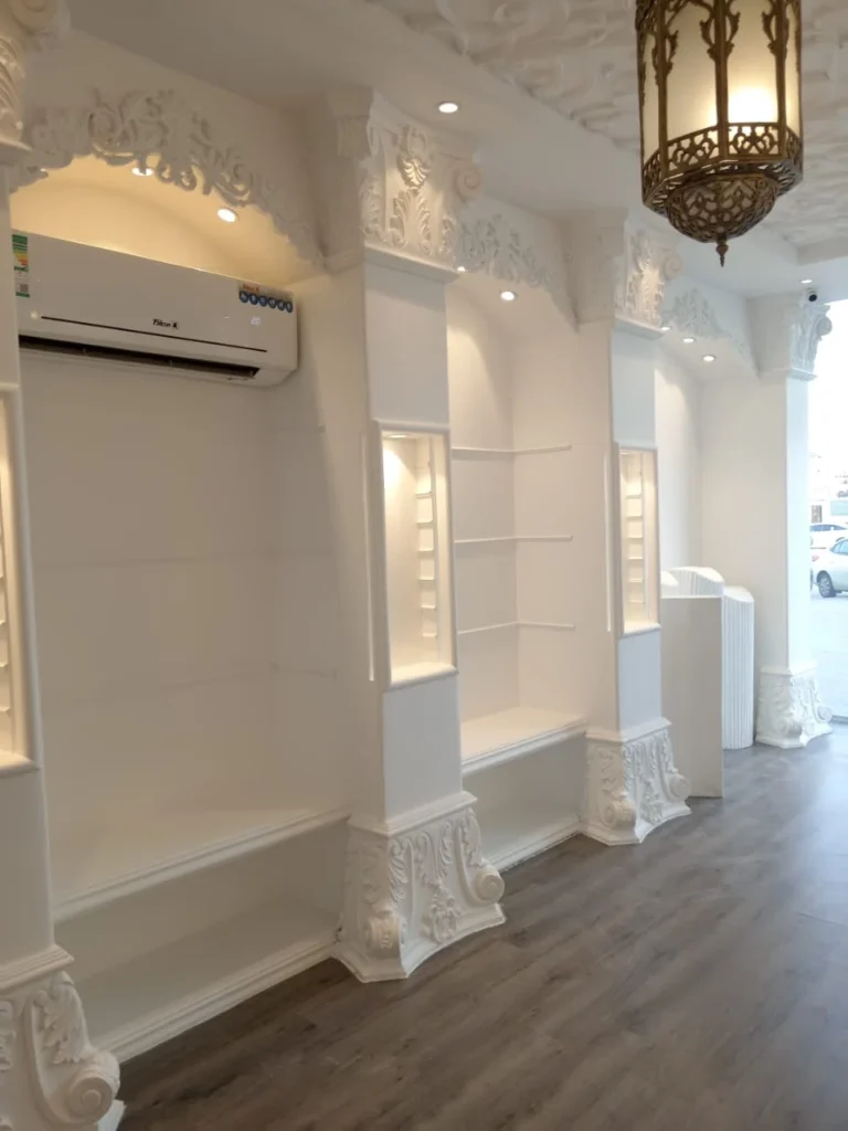 دهانات داخلية بيضاء فاخرة بتشطيب ناعم، تُبرز التفاصيل الجبسية والنقوش الكلاسيكية